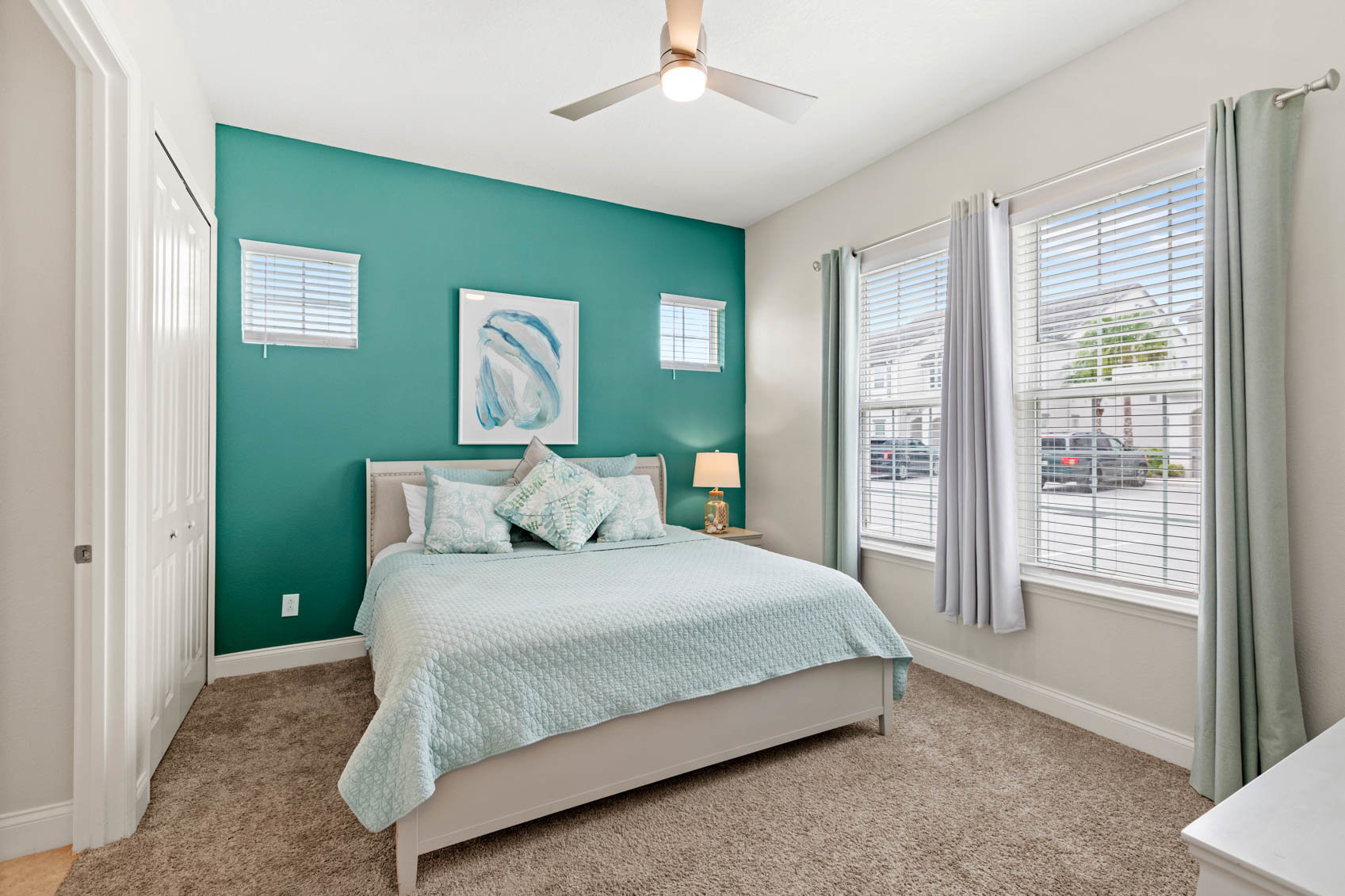 downstairs bedroom with window looking outside and teal bed